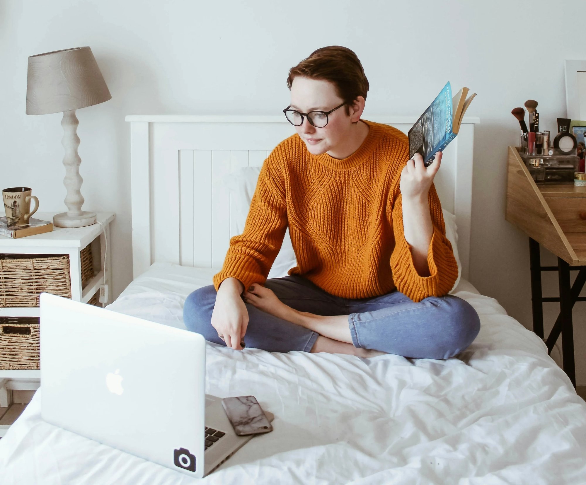 Woman with laptop and book in hands