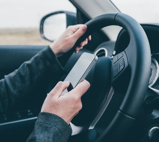 Person holding phone inside a car