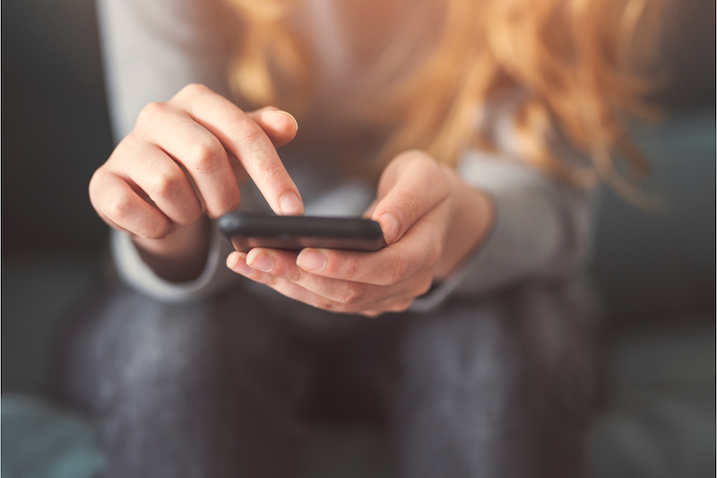 Person typing on phone