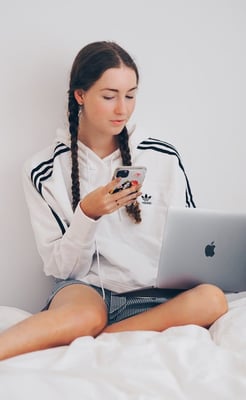 Teenager on phone and laptop