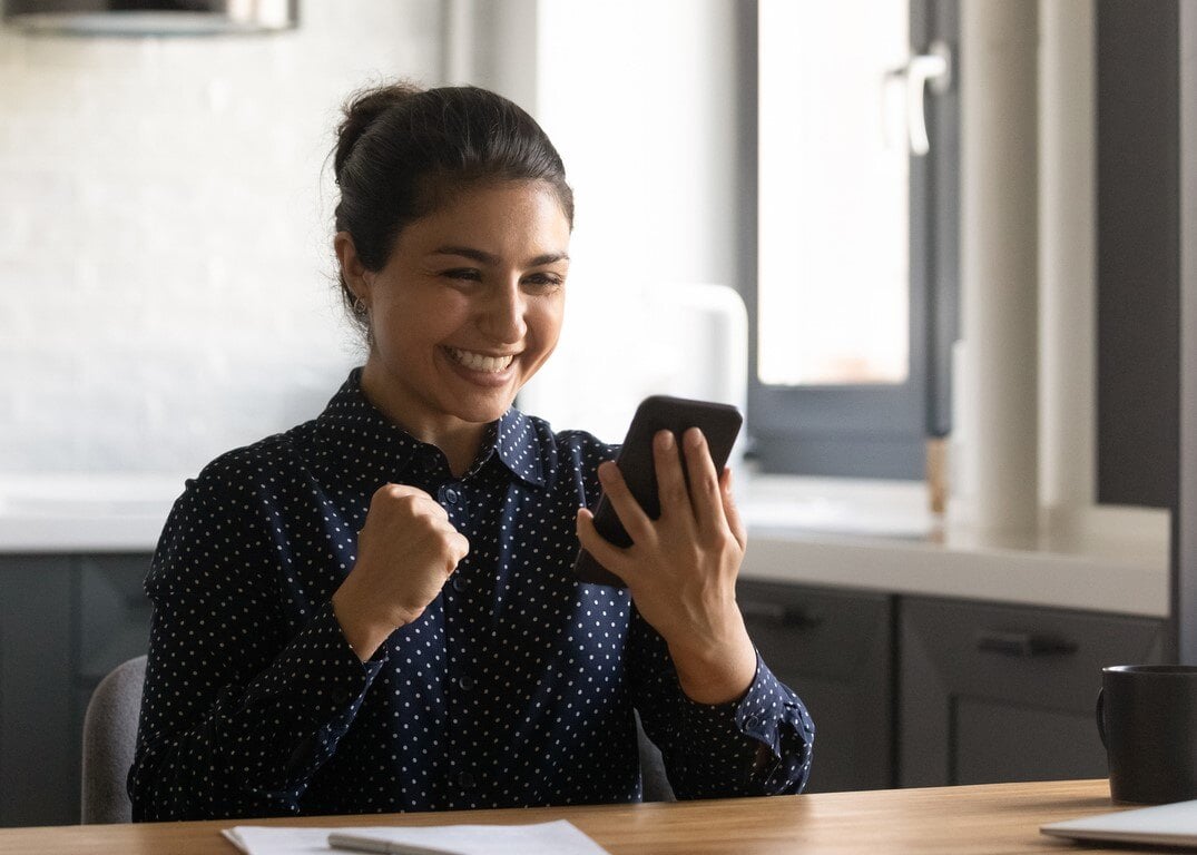 Glückliche Frau schaut auf ihr Handy