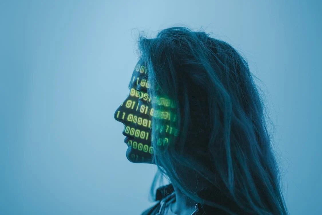 Frau wird mit Projektor Binärcode auf Gesicht gestrahlt Frau wird mit Projektor Binärcode auf Gesicht gestrahlt